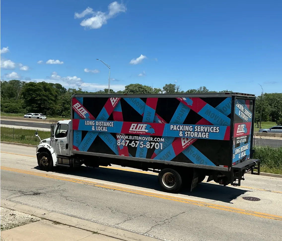 Elite Moving & Storage truck traveling a frontage road beside a highway in Mundelein IL